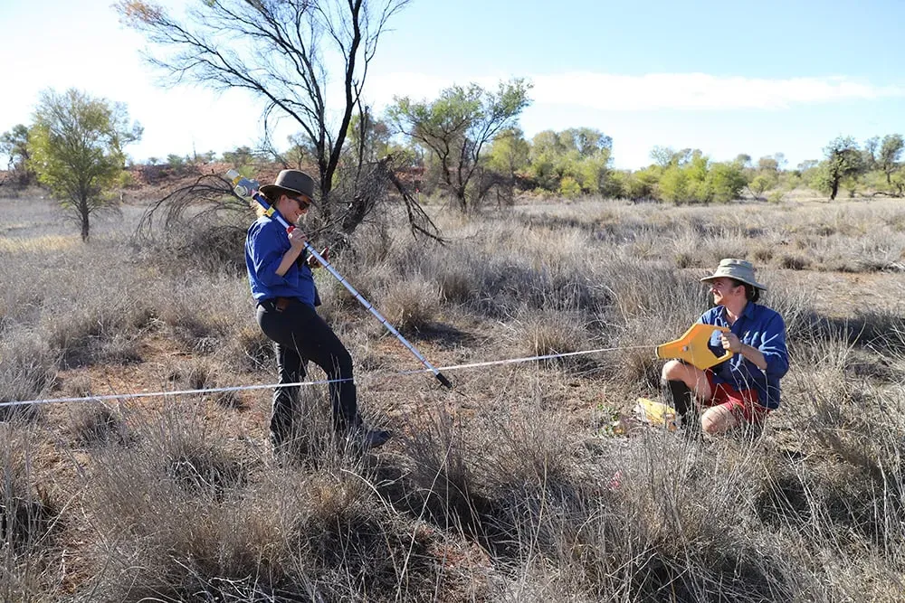 Field workers recording vegetation measurements at a survey site in the Australian rangelands.