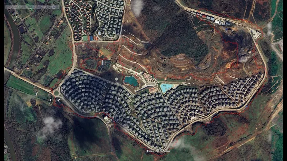 Aerial photograph of a hillside in Turkey with a red polygon outlining a block of new houses standing where forest used to be.