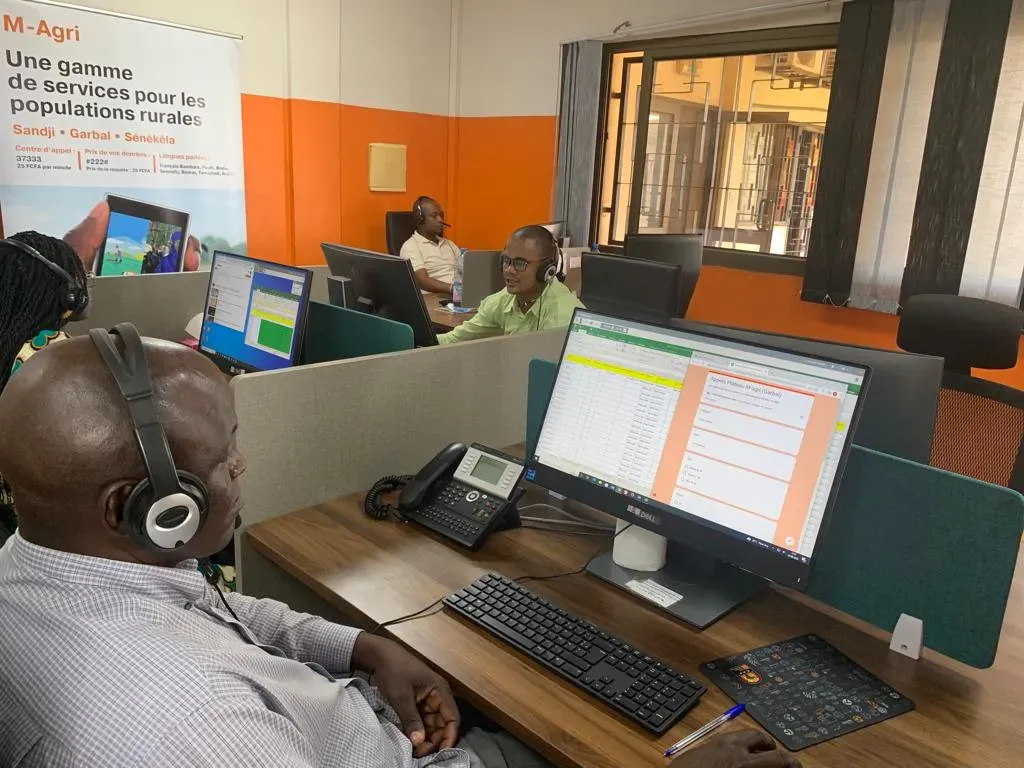 Call-centre operators wearing headsets at their computer desks.