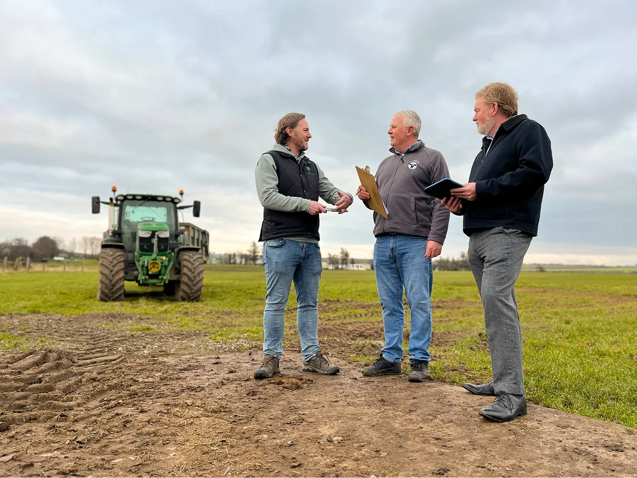 Three members of the project team standing together in a grass field.