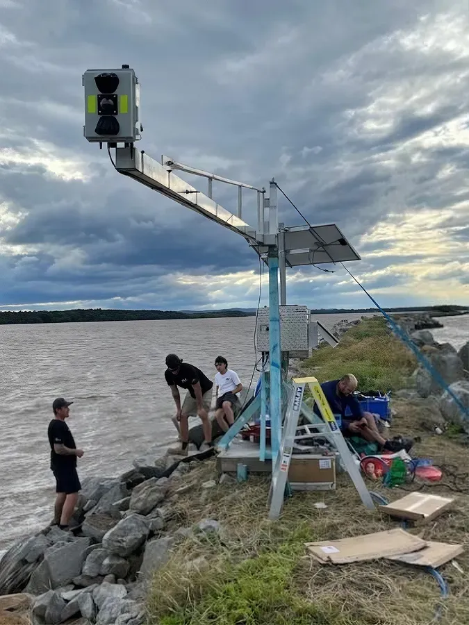A sensor unit mounted on a coastal structure above the water, part of a real-time water quality monitoring installation.