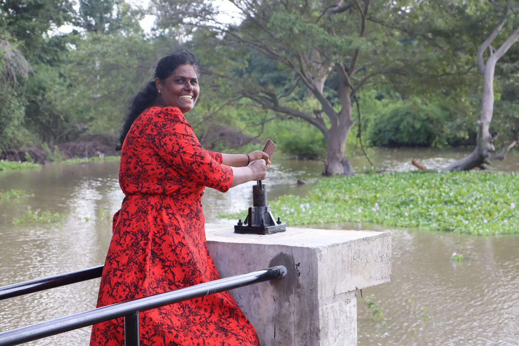 A community member operating an irrigation gate on a tank as part of the SARP project.