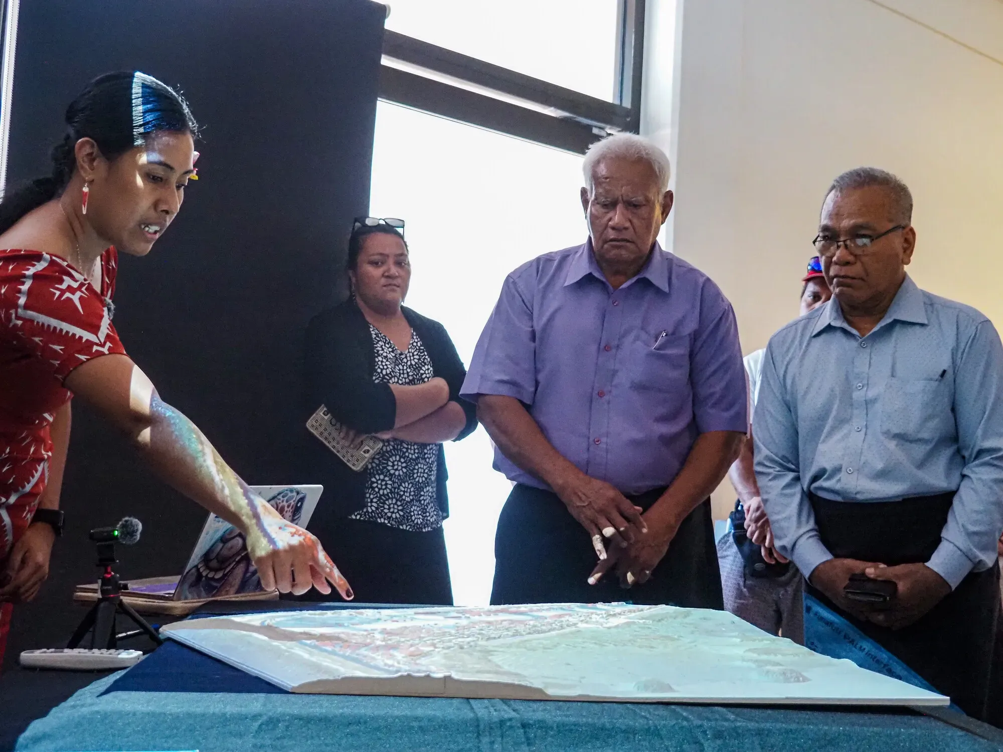 A physical three-dimensional model of a Tuvaluan atoll being demonstrated at its handover.