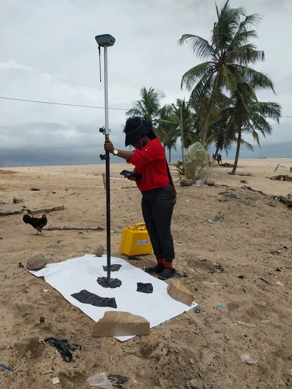 Researchers surveying the shoreline in the field, taking measurements to record shoreline change and map future flood extent.